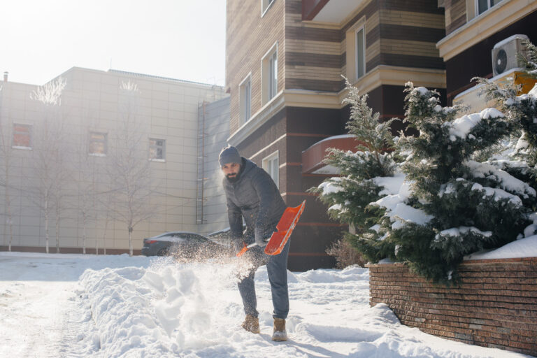 A utility worker cleans a path with a machine-driven snowplow during a snowfall.